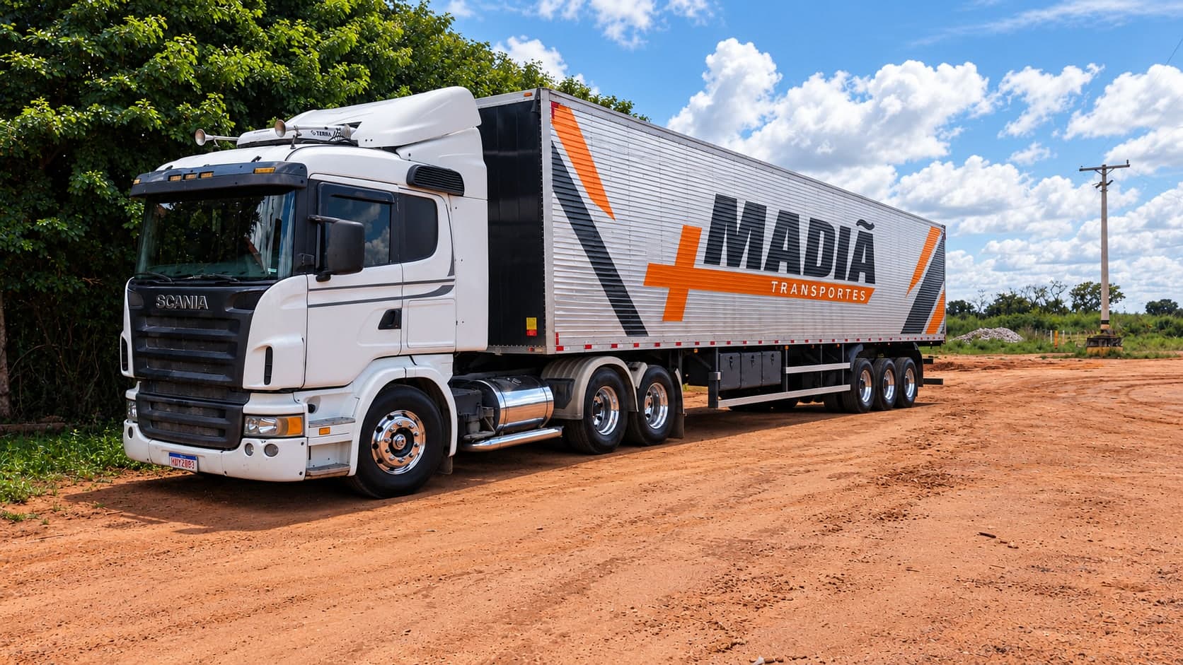 Carreta baú da Madiã Transportes com cavalo Scania em estrada de terra